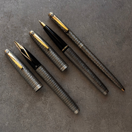 Set of luxury pens with metallic accents on a textured surface