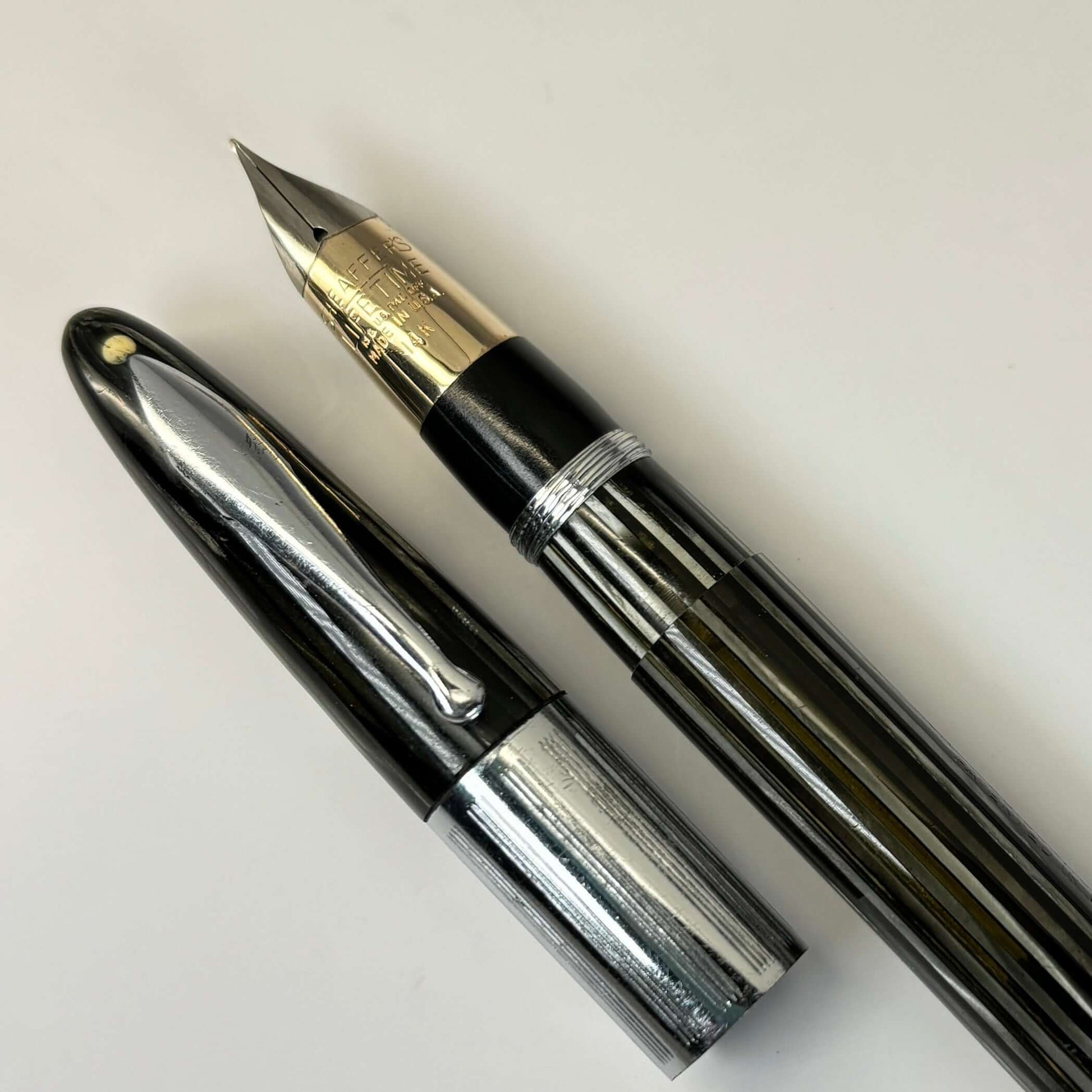 1940s Sheaffer Triumph Vac-fil, Extra-wide cap Band, Pearl Grey with Chrome trim. Medium Two-tone Nib Length: 5 1/8 Filling System: Vacuum-Fil; restored with new seals Color/Pattern: Pearl Grey with chrome trim Nib Type/Condition and remarks: Medium two-t