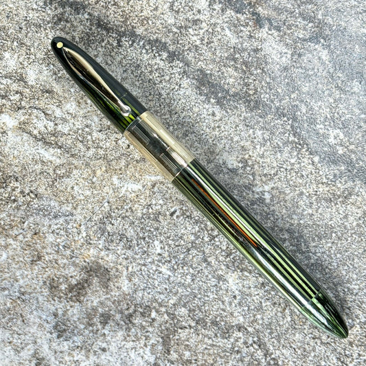 1940s Sheaffer Triumph Vacuum-fil, Extra-wide cap Band, Marine Green with gold filled trim. Fine/Medium Two-tone Nib Length: 5 1/8 Filling System: Vacuum-Fil; restored with new seals Color/Pattern: Marine Green with gold-filled trim Nib Type/Condition and