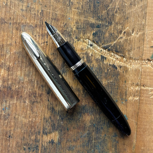 Sheaffer Tuckaway Crest, Black with Gold-Filled CapName/Type: Sheaffer Tuckaway Crest Manufacture Year: 1940s Length: 4 1/2 Filling System: Restored Vac-Fil Color/Pattern: Black with gold-filled cap Nib Type/Condition and remarks: Large two-tone 14K conic
