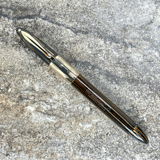 1940s Sheaffer Triumph Vacuum-fil, Extra-wide cap Band, Golden Brown with gold filled trim. Fine Two-tone Nib Length: 5 1/8 Filling System: Vacuum-Fil; restored with new seals Color/Pattern: Golden Brown with gold-filled trim Nib Type/Condition and remark