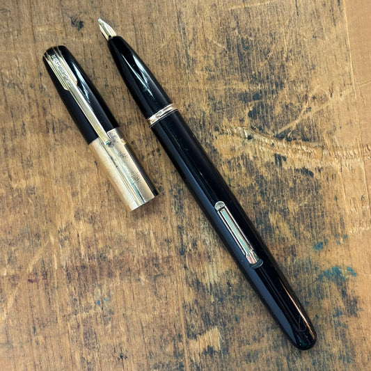 Waterman Taperite Citation, Black with Gold Filled TrimName/Type: Waterman Taperite Manufacture Year: 1940s Length: 5 1/4 Filling System: Lever Filler Color/Pattern: Black with Gold Filled Trim Nib Type/Condition and remarks: Medium 14K Nib; Fairly respon