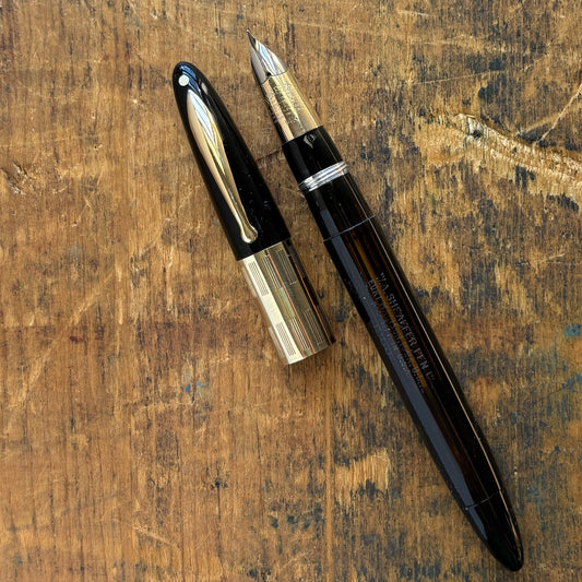 Sheaffer Triumph Vacuum-fil, Black, Extra-wide cap Band, Fine Two-tone NibLength: 5 1/8 Filling System: Vacuum-Fil; restored with new seals Color/Pattern: Black with gold-filled trim Nib Type/Condition and remarks: Fine two-tone 14K gold trim, smooth wet