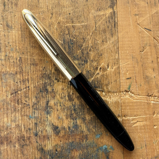 Sheaffer Triumph Crest Deluxe 1500 Fountain PenName/Type: Sheaffer Triumph Crest Deluxe Manufacture Year: 1940s Length: 5 1/4 Filling System: Vac-fil; restored with new sac Color/Pattern: Black barrel with gold-filled cap Nib Type/Condition and remarks: L