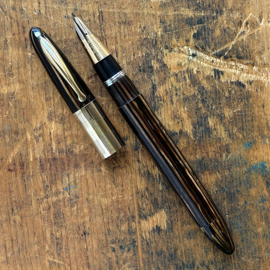 Sheaffer Triumph Vacuum-fil, Golden Brown, Extra-wide cap Band, Fine Two-tone NibLength: 5 1/8 Filling System: Vacuum-Fil; restored with new seals Color/Pattern: Golden Brown with gold-filled trim Nib Type/Condition and remarks: Fine two-tone 14K gold tri
