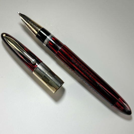 1940s Sheaffer Triumph Vacuum-fil, Extra-wide cap Band, Carmine Red with gold filled trim. Medium Two-tone Nib Length: 5 1/8 Filling System: Vacuum-Fil; restored with new seals Color/Pattern: Carmine Red with gold-filled trim Nib Type/Condition and remark