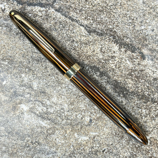 Sheaffer Statesman Restored Vac-fil Fountian Pen, 14K Triumph Fine Nib, Gold-filled trim. Name/Type: Sheaffer Statesman Manufacture Year: 1945 Length: 5 Filling System: Vac-fil, restored with new seals. Color/Pattern: Golden Brown with gold-filled cap and