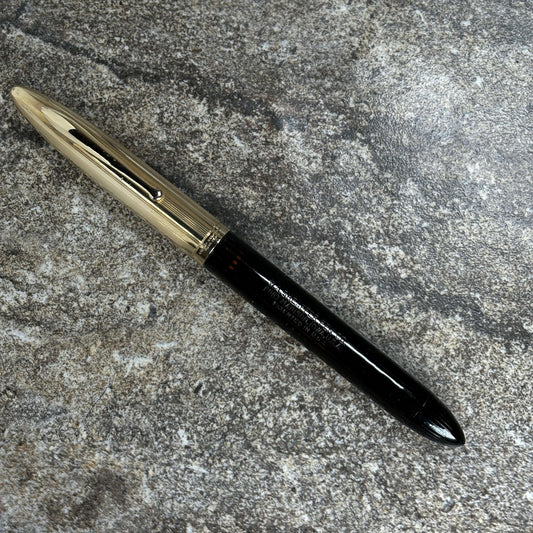 Sheaffer Crest, Restored Vac- Filler, Black with Gold Filled Cap, 14K Two-tone Nib Name/Type: Sheaffer Crest Length: 5 1/2 Filling System: Vac- Filler; restored with new seals Color/Pattern: Black Celluloid, Ambered Ink View, Dent free Gold Cap Nib Type/C