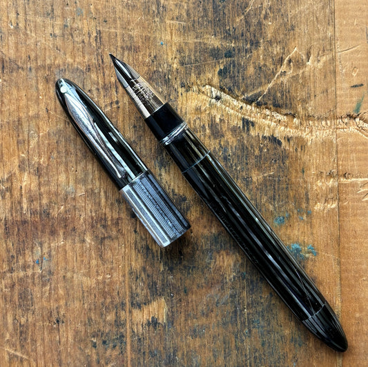 Sheaffer Triumph Vacuum-fil, Gray Pearl, Extra-wide cap BandLength: 5 1/8 Filling System: Vacuum-Fil; restored with new seals Color/Pattern: Gray pearl with gold-filled trim Nib Type/Condition and remarks: Medium two-tone 14K gold trim, smooth wet line. C