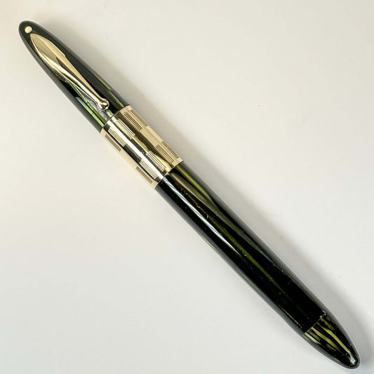 1940s Sheaffer Triumph Vac-fil, Extra-wide cap Band, Marine Green with Gold-filled trim. Medium Two-tone Nib Length: 5 1/8 Filling System: Vacuum-Fil; restored with new seals Color/Pattern: Marine Green with gold-filled trim Nib Type/Condition and remarks