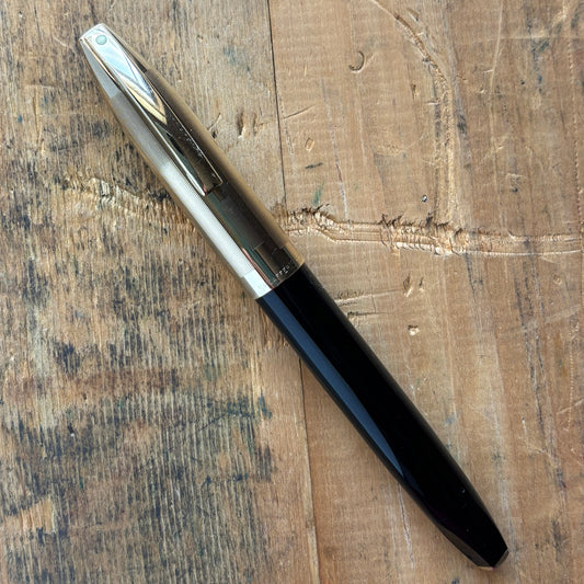 Sheaffer PFM V, Fully Restored in Black with Gold Filled CapName/Type: Sheaffer Pen For Men V Manufacture Year: 1959-1968 Length: 5 3/8 Filling System: Snorkel, restored with new sac and seals Color/Pattern: Black with gold-filled cap Nib Type/Condition a