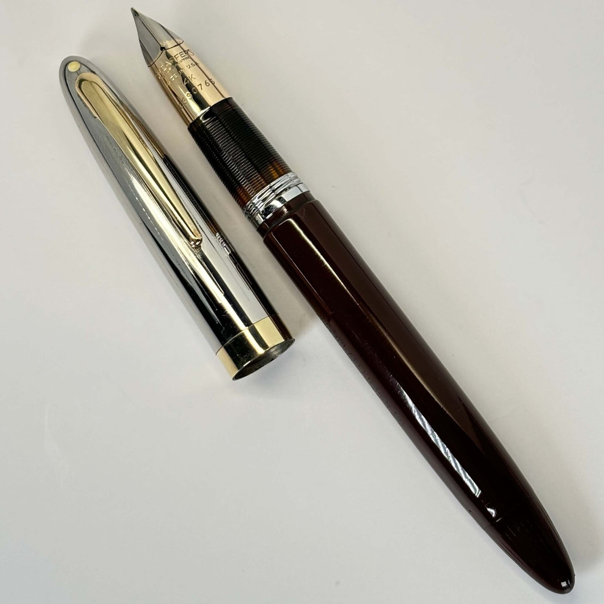 Sheaffer Touchdown; Burnt Umber Brown, Large Two-tone 14K nib. Name/Type: Sheaffer Touchdown Manufacture Year: 1949 Length: 5 1/4 Filling System: Touchdown; new sac and seals Color/Pattern: Burnt Umber Brown with two-tone cap Nib Type/Condition and remark