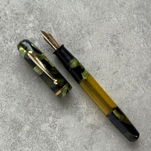 Fountain pen with green and black design on a gray surface