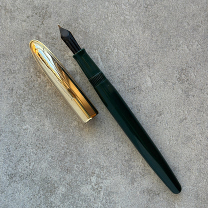 Fountain pen with gold cap and black body on a gray surface