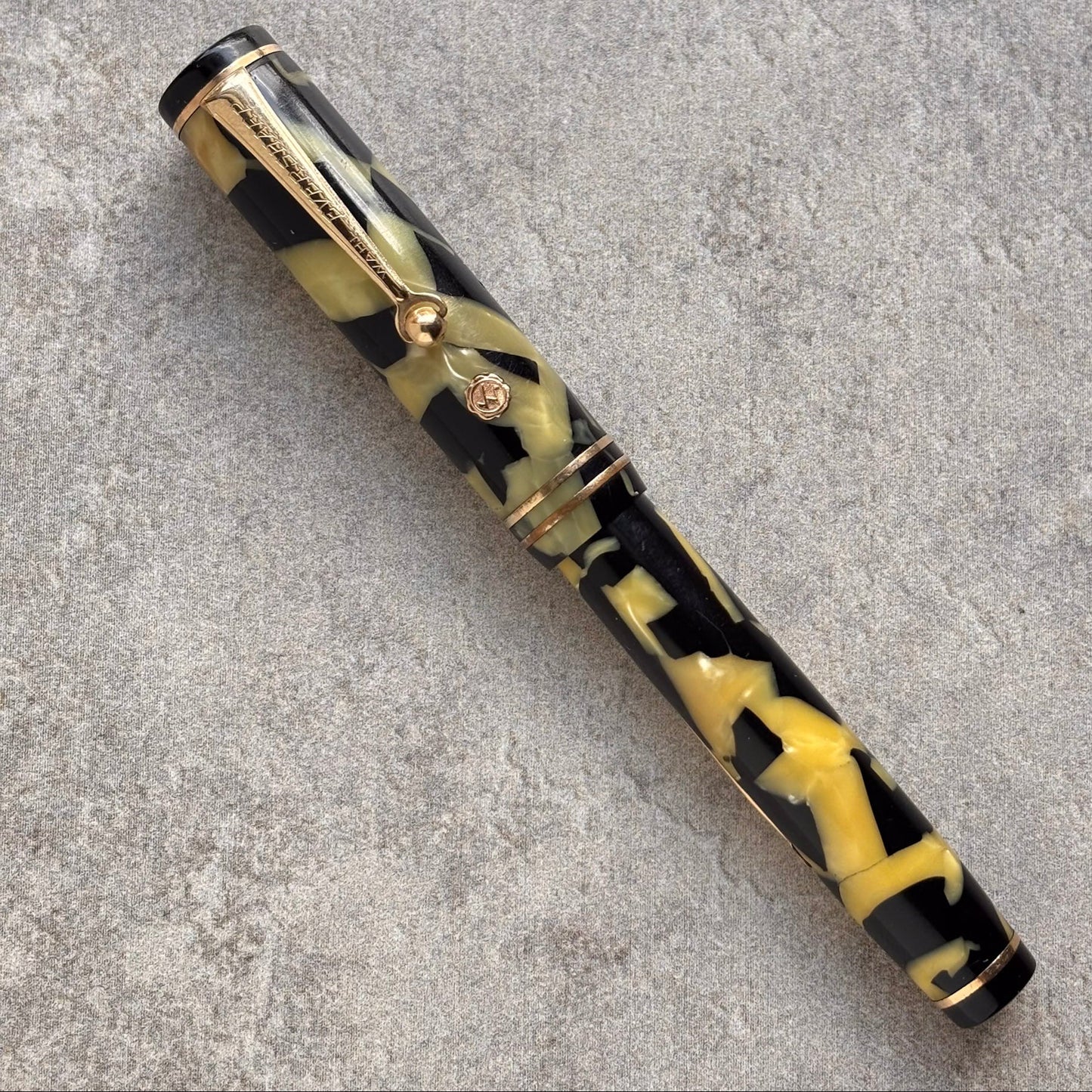 Fountain pen with black and yellow pattern on a gray surface