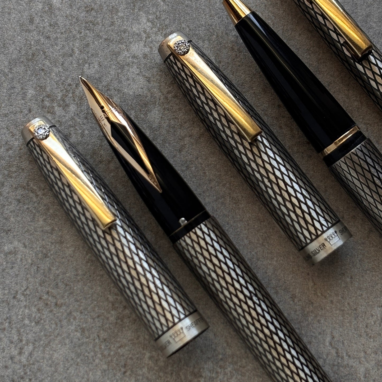 Set of luxury pens with gold accents on a textured surface