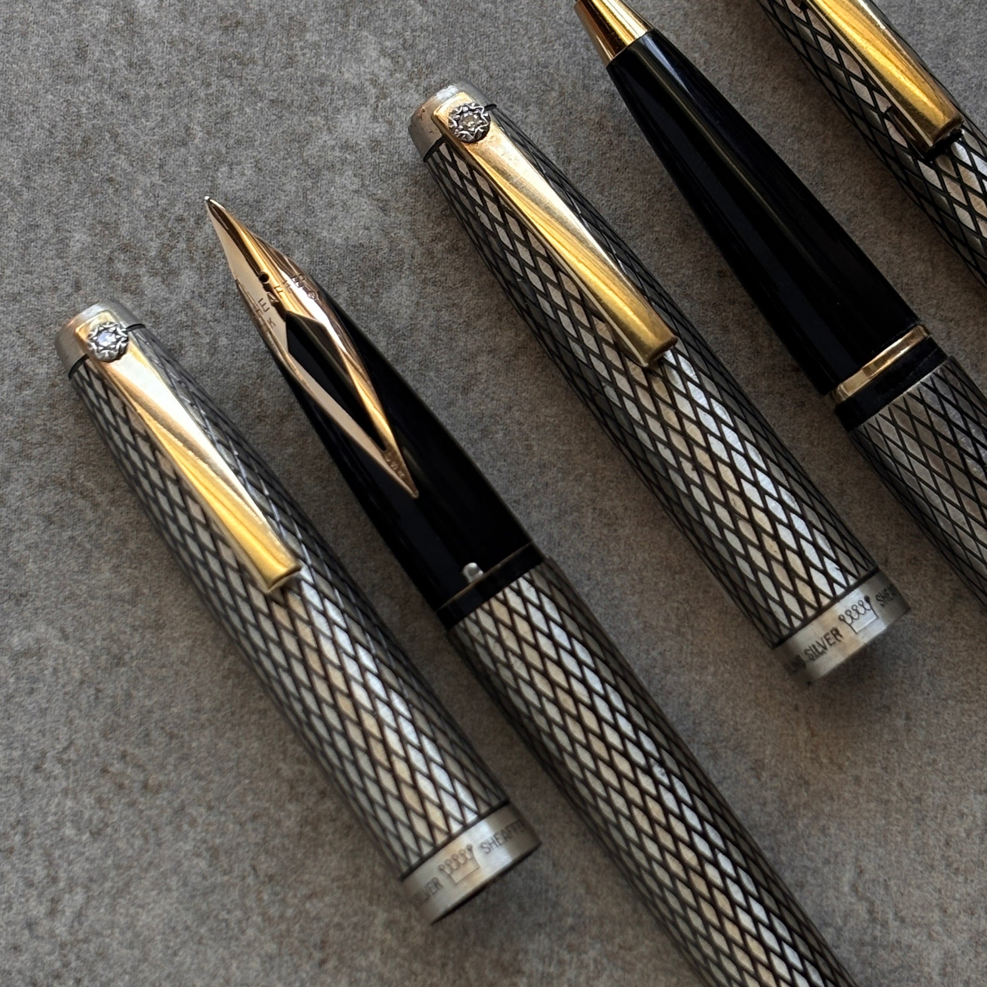 Set of luxury pens with gold accents on a textured surface