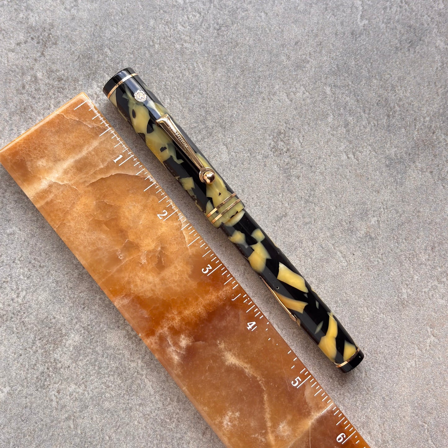 Fountain pen with tortoiseshell pattern next to a ruler on a gray surface