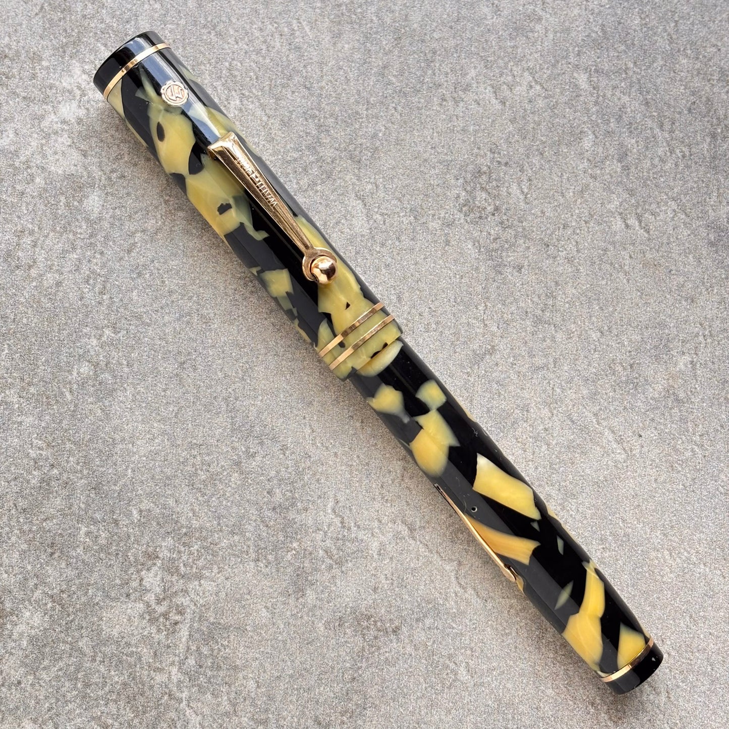 Fountain pen with black and yellow pattern on a gray surface