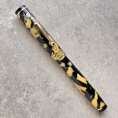 Fountain pen with black and yellow pattern on a gray surface
