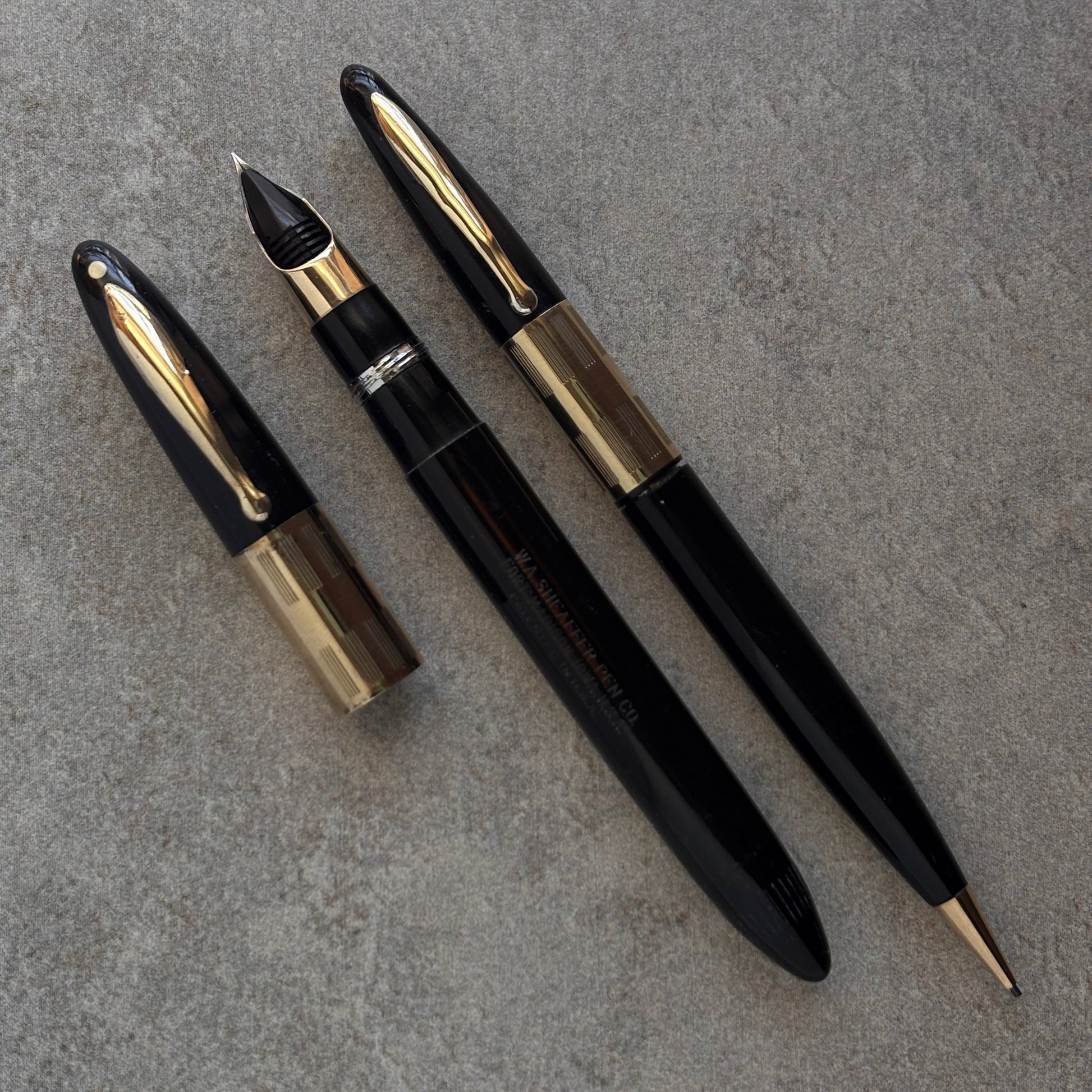 Black and gold fountain pen on a gray surface