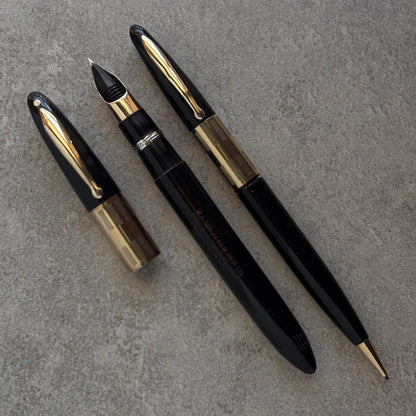 Black and gold fountain pen on a gray surface