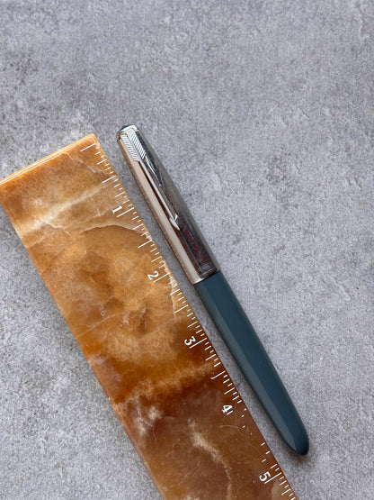 Pen and ruler on a textured gray surface