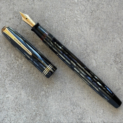 Blue fountain pen with gold accents on a gray surface