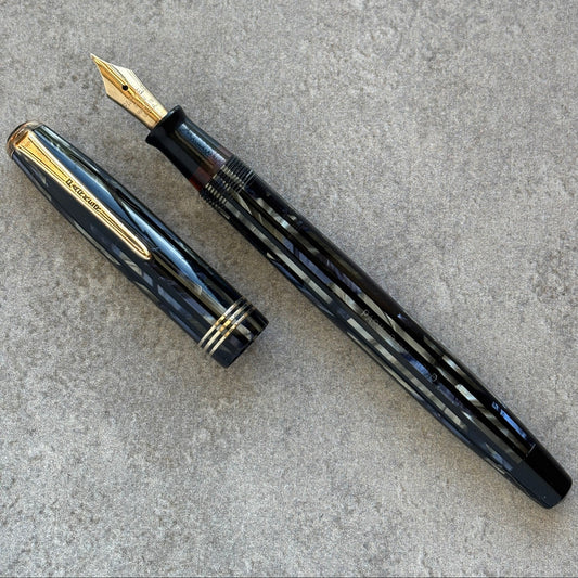 Blue fountain pen with gold accents on a gray surface