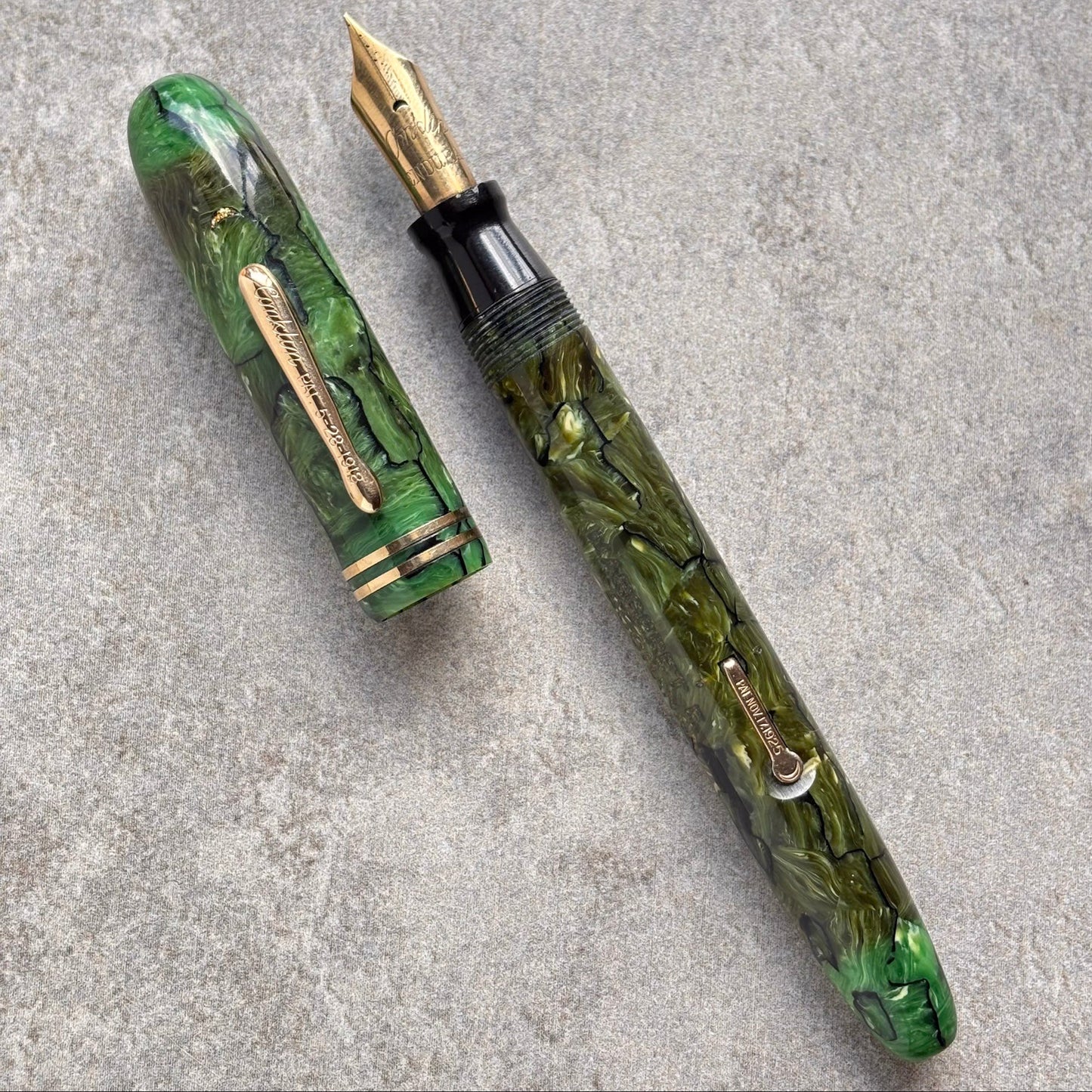 Green marbleized fountain pen on a gray surface
