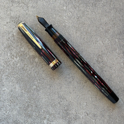 Fountain pen and its cap on a gray concrete surface