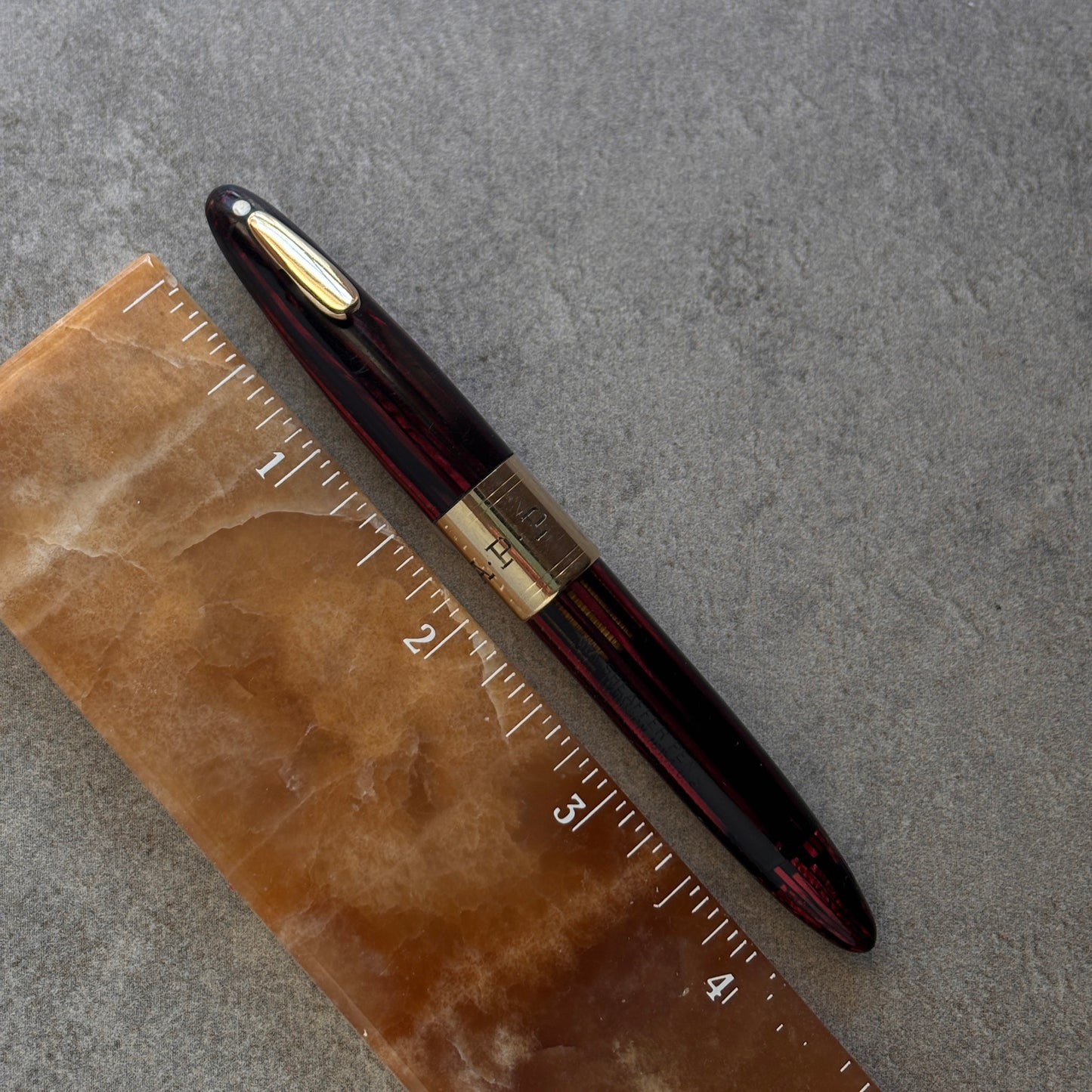 Fountain pen on a marble surface with a ruler for scale