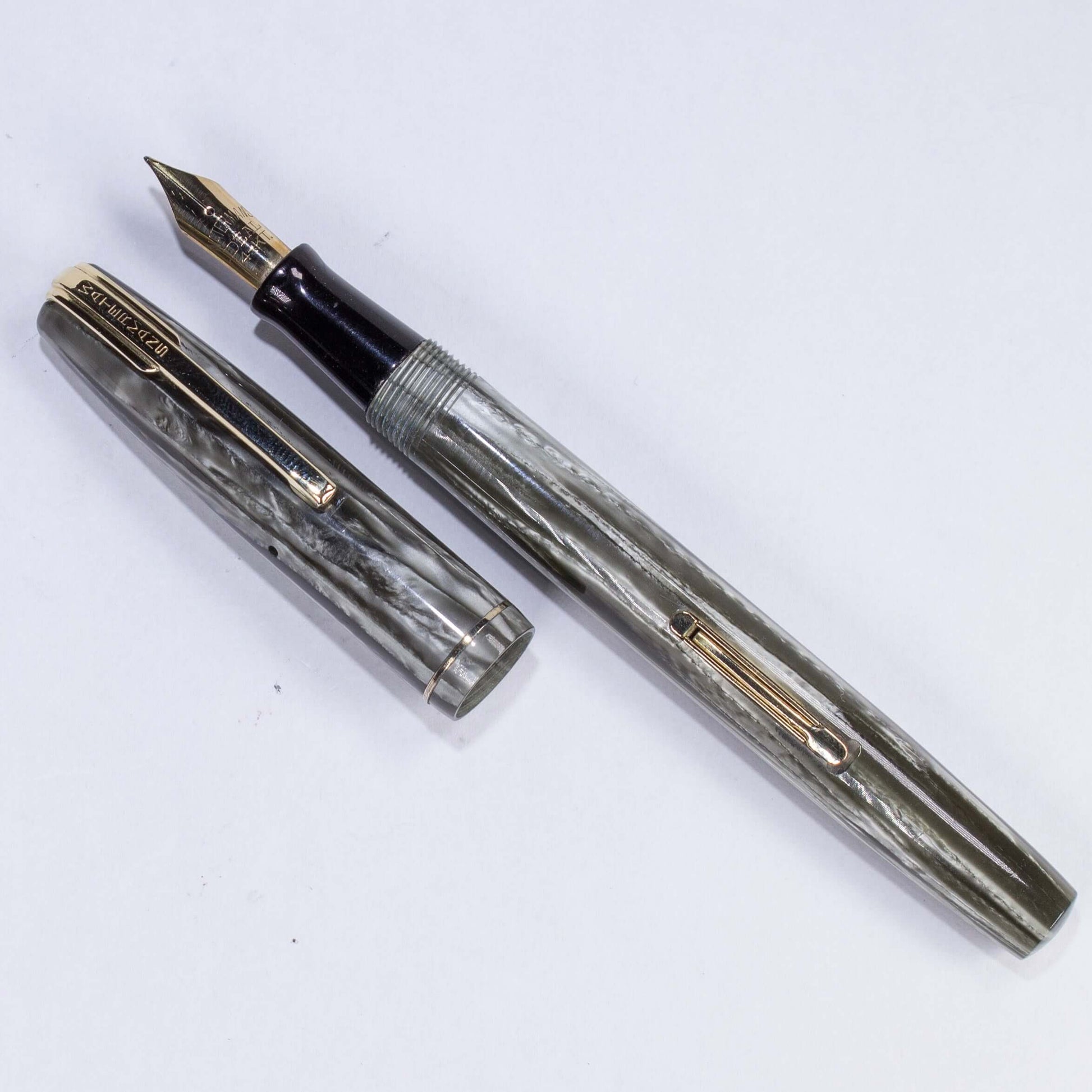 ${title﻿Name/Type: Waterman Stalwart Manufacture Year: Circa late 1940s Length: 5 Filling System: Lever Filler with new sac Color/Pattern: Striped Grey Marble, Gold plated clip and trim Nib Type/Condition and remarks: Medium 14K Gold Waterman nib, a littl