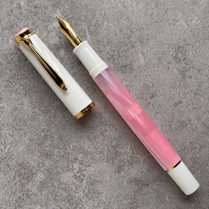 Fountain pen with white and pink design on a gray surface