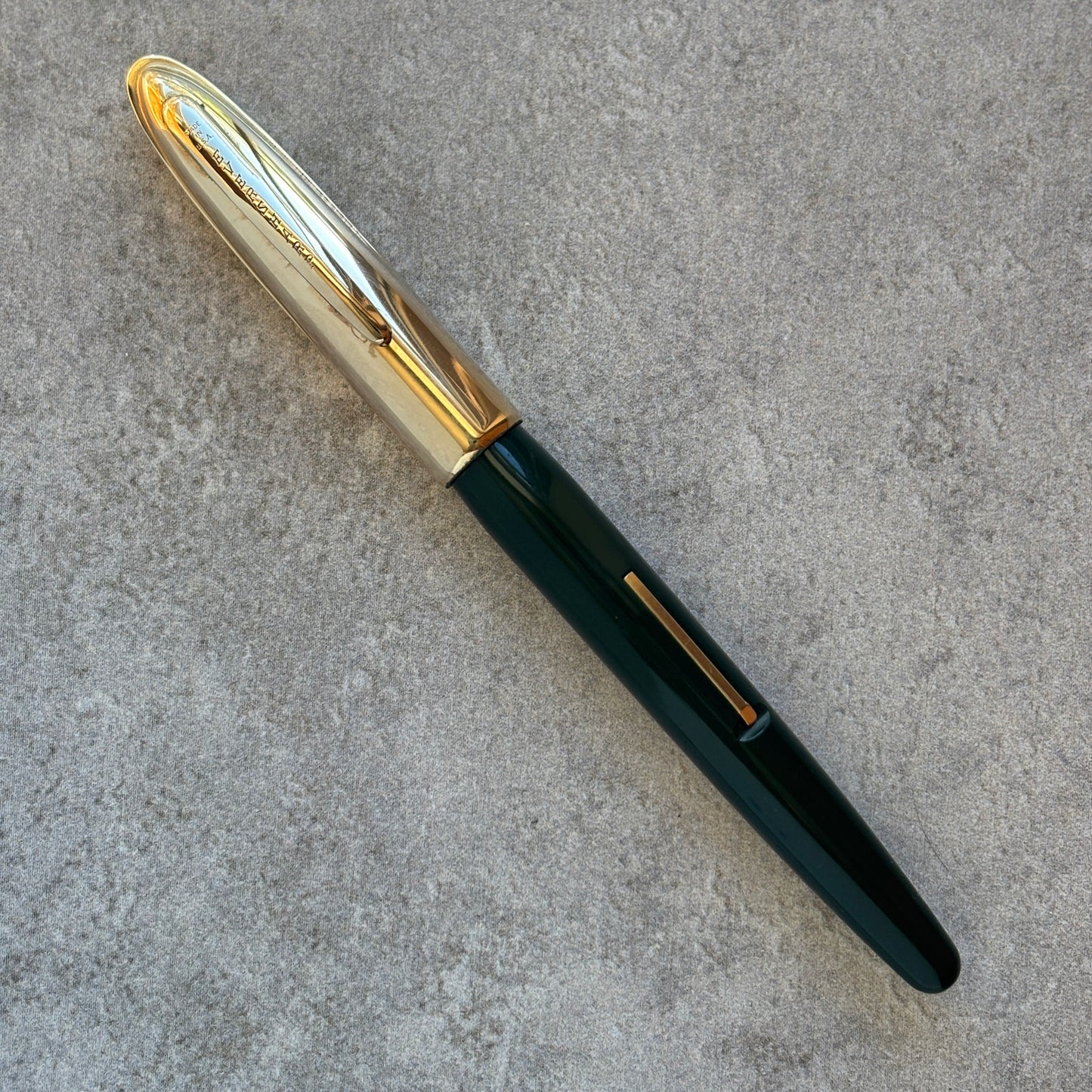 Fountain pen with gold accents on a gray surface