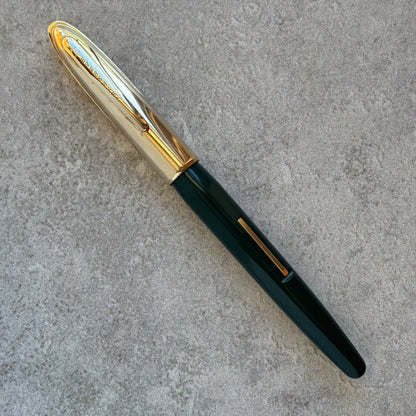 Fountain pen with gold accents on a gray surface