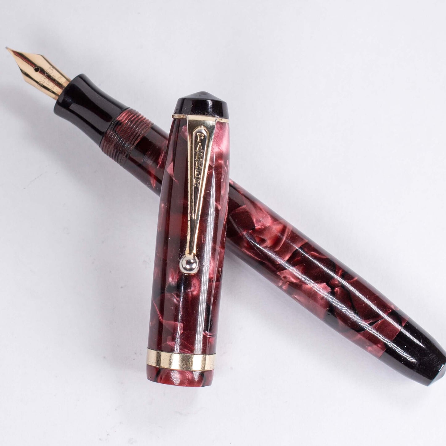 Parker Challenger Fountain Pen, Red Marbled, Button Filler, 14K Gold Nib Name/Type: Parker Challenger Restored Vintage Fountain Pen Manufacture Year: 1930s Length: 5 Filling System: Button Filler Color/Pattern: Red Marbled, Gold filled trim and cap band N