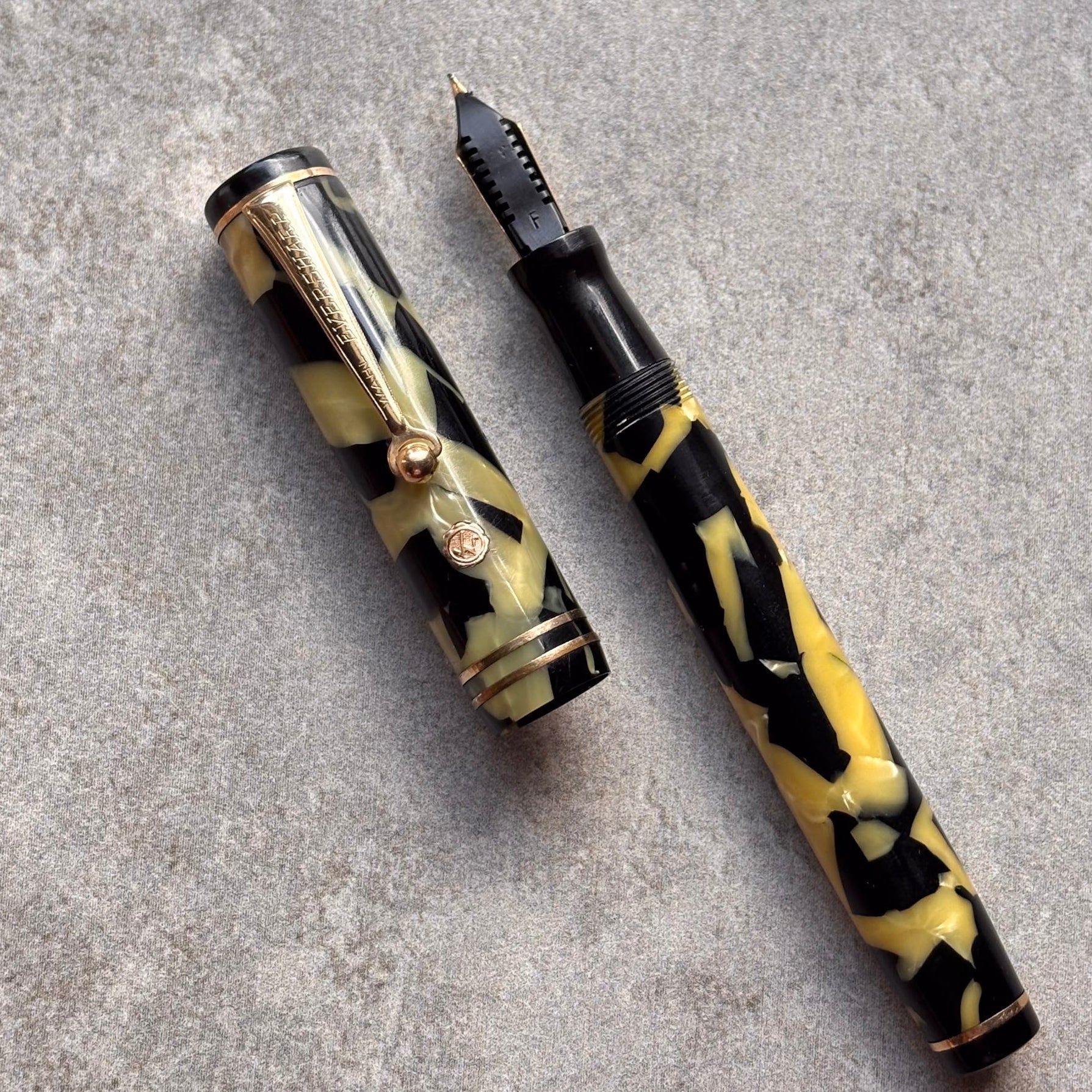 Fountain pen with a black and yellow pattern on a gray surface