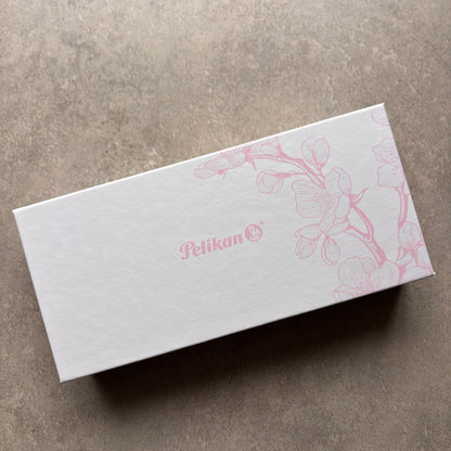 White box with pink floral design and 'Pelikan' logo on a gray surface
