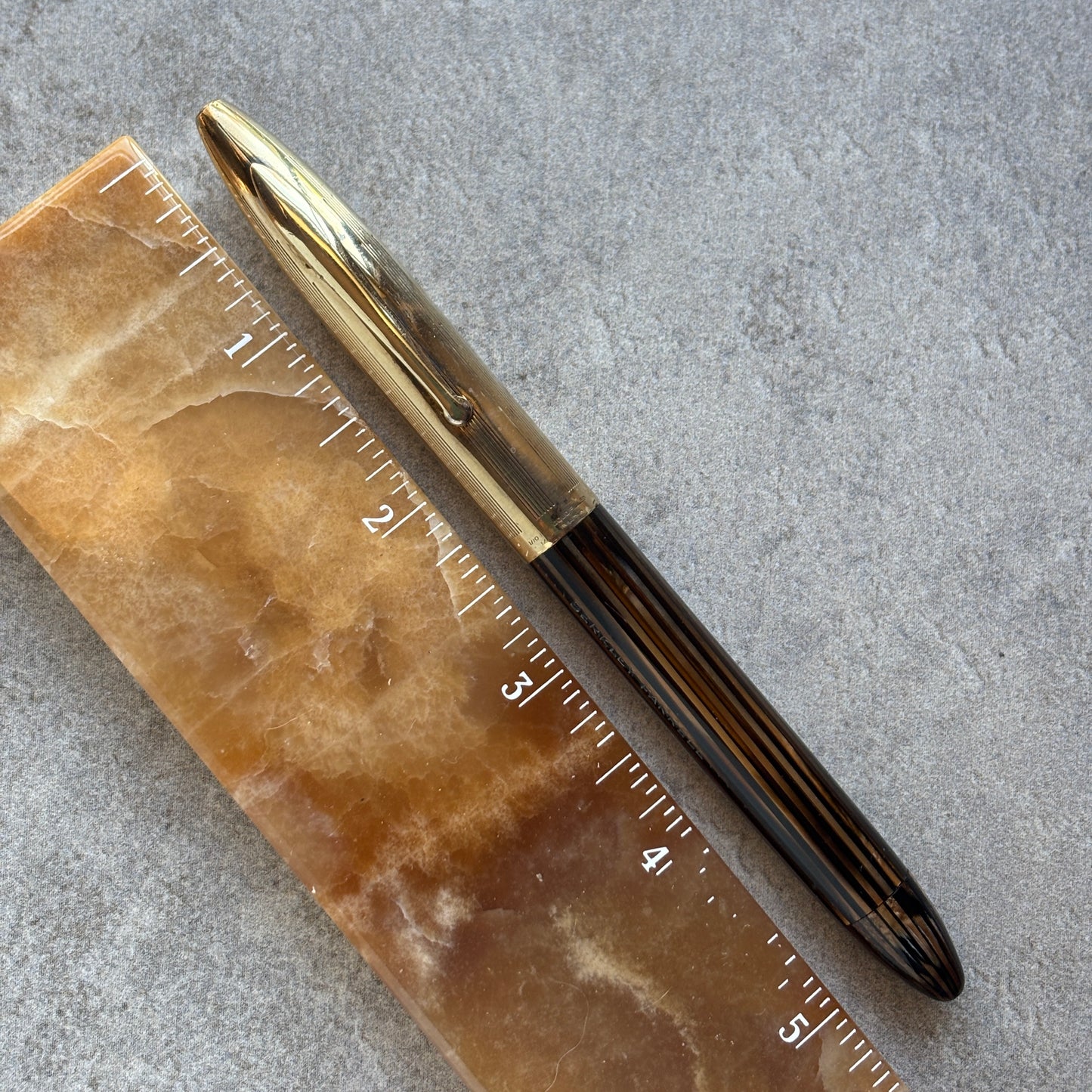 Pen on a marble surface with a ruler for scale