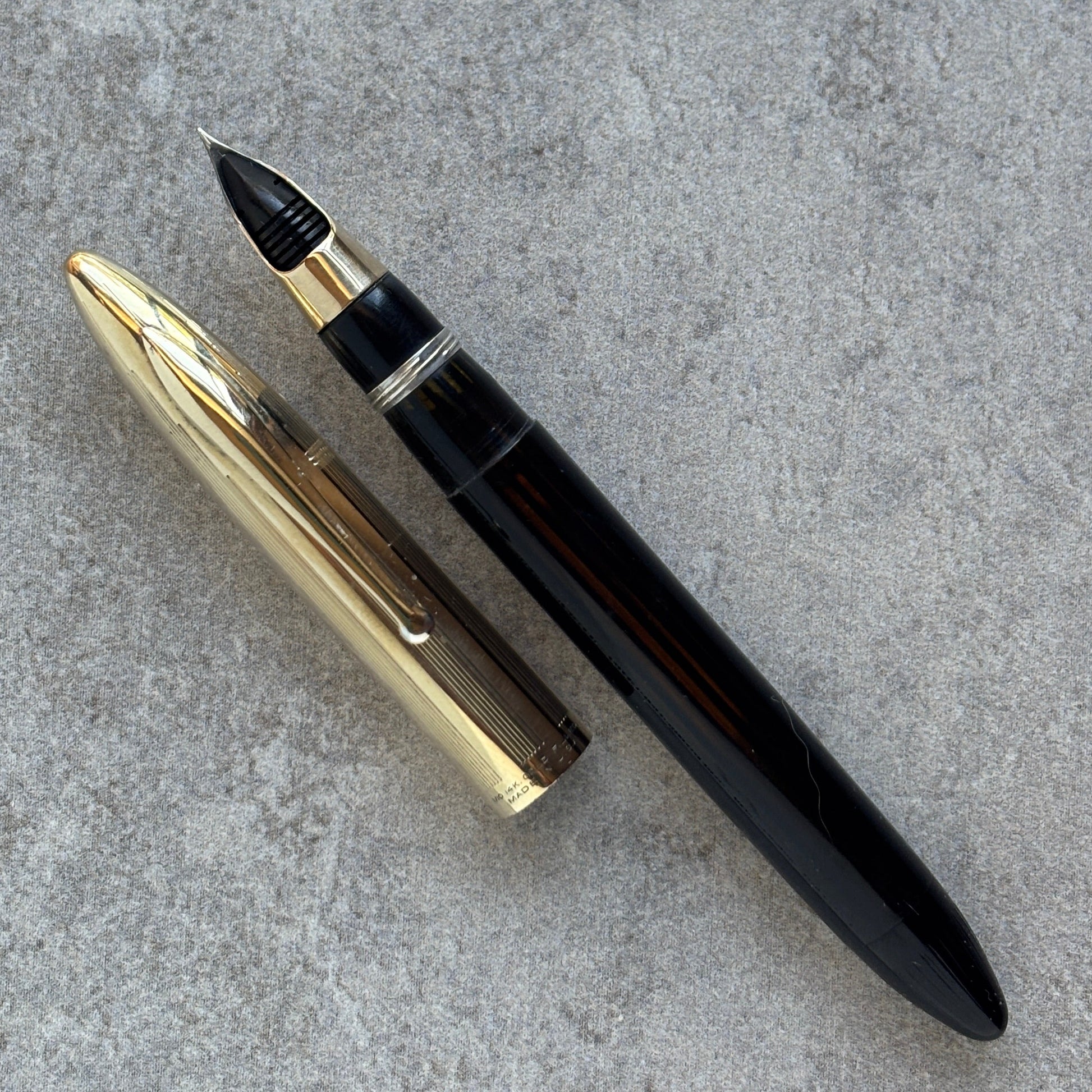 Fountain pen with gold and black accents on a gray surface