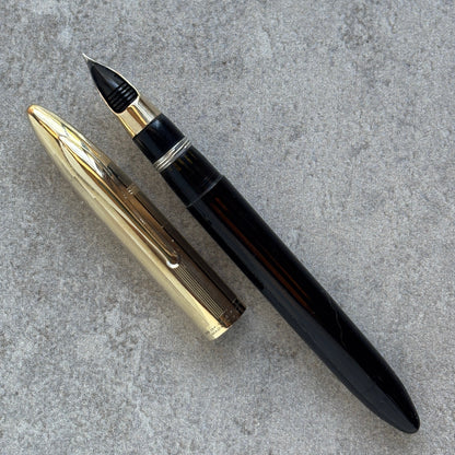 Fountain pen with gold and black accents on a gray surface