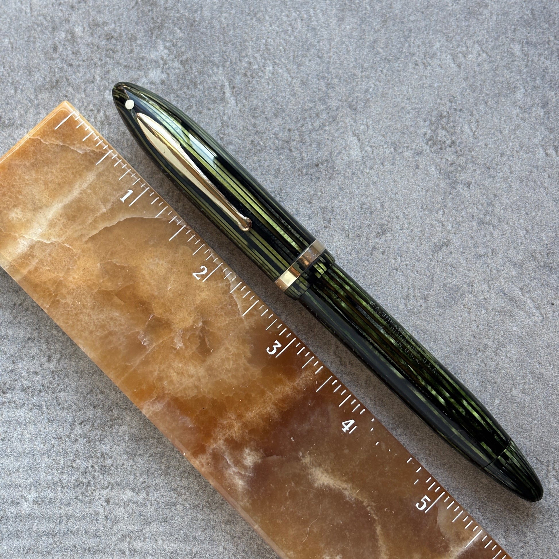 Fountain pen on a stone surface with a ruler for scale