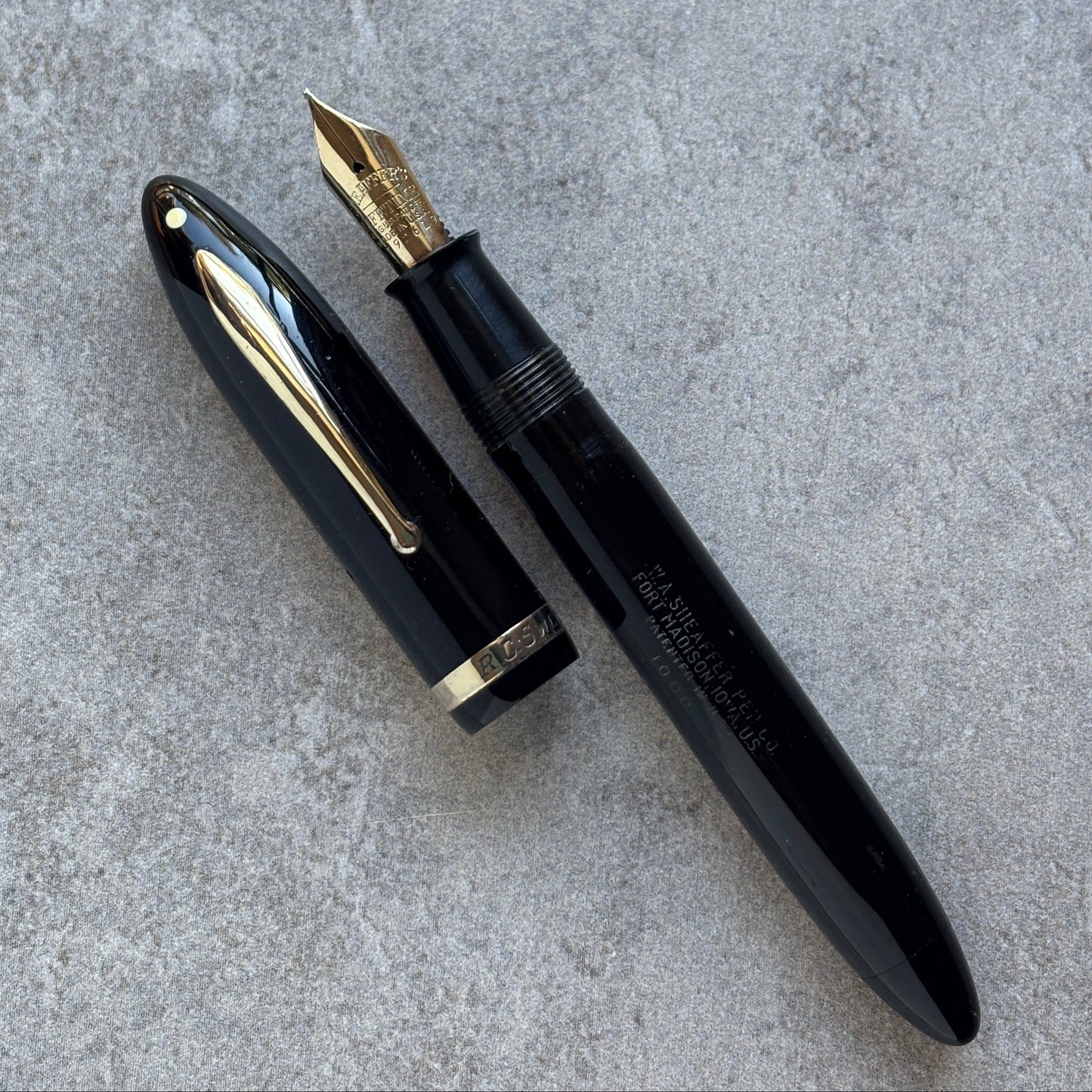Black fountain pen with gold accents on a gray surface