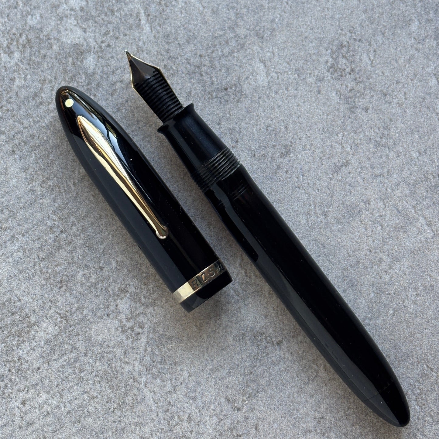 Black fountain pen on a gray concrete surface