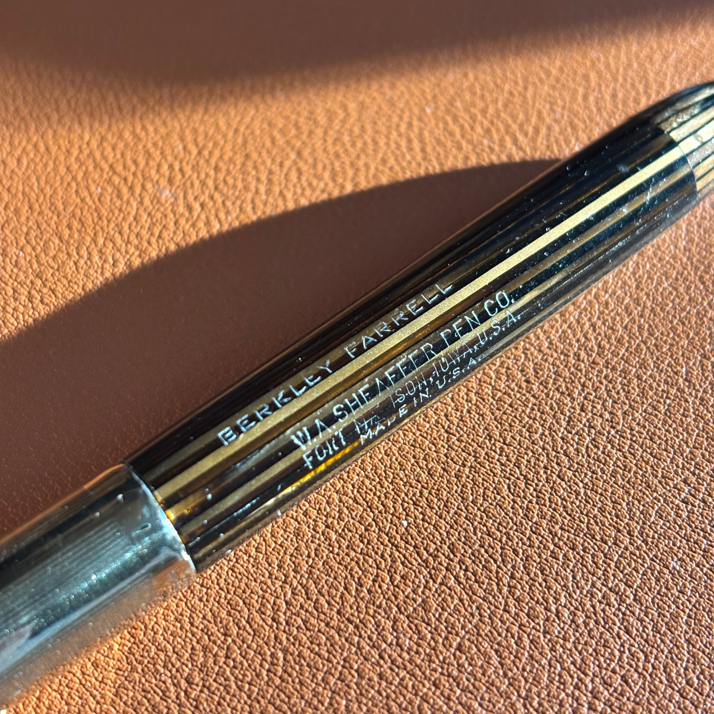 Close-up of a pen with 'Berkley Ferris' branding on a brown barrel