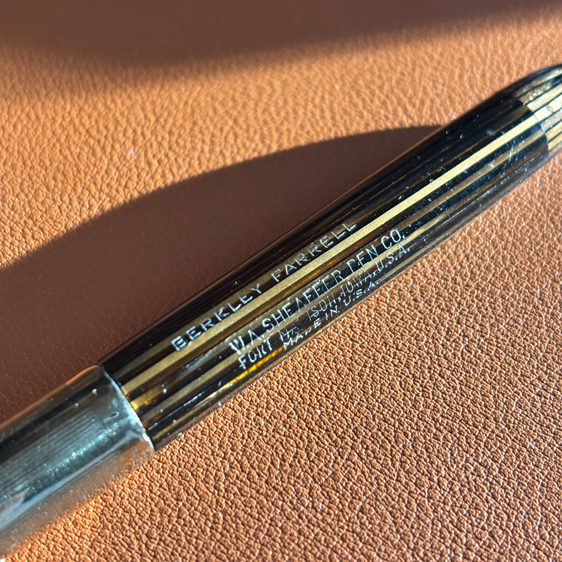 Close-up of a pen with 'Berkley Ferris' branding on a brown barrel