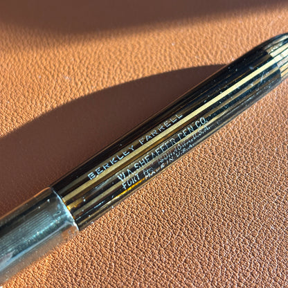 Close-up of a pen with 'Berkley Ferris' branding on a brown barrel