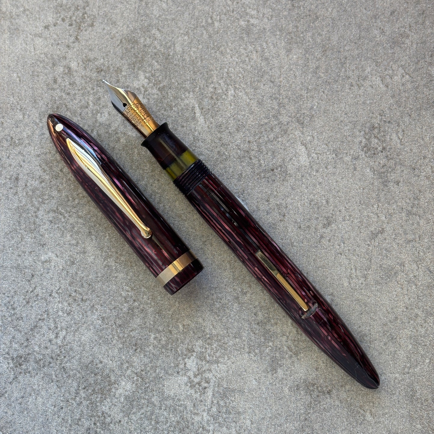 Fountain pen with gold accents on a gray concrete surface