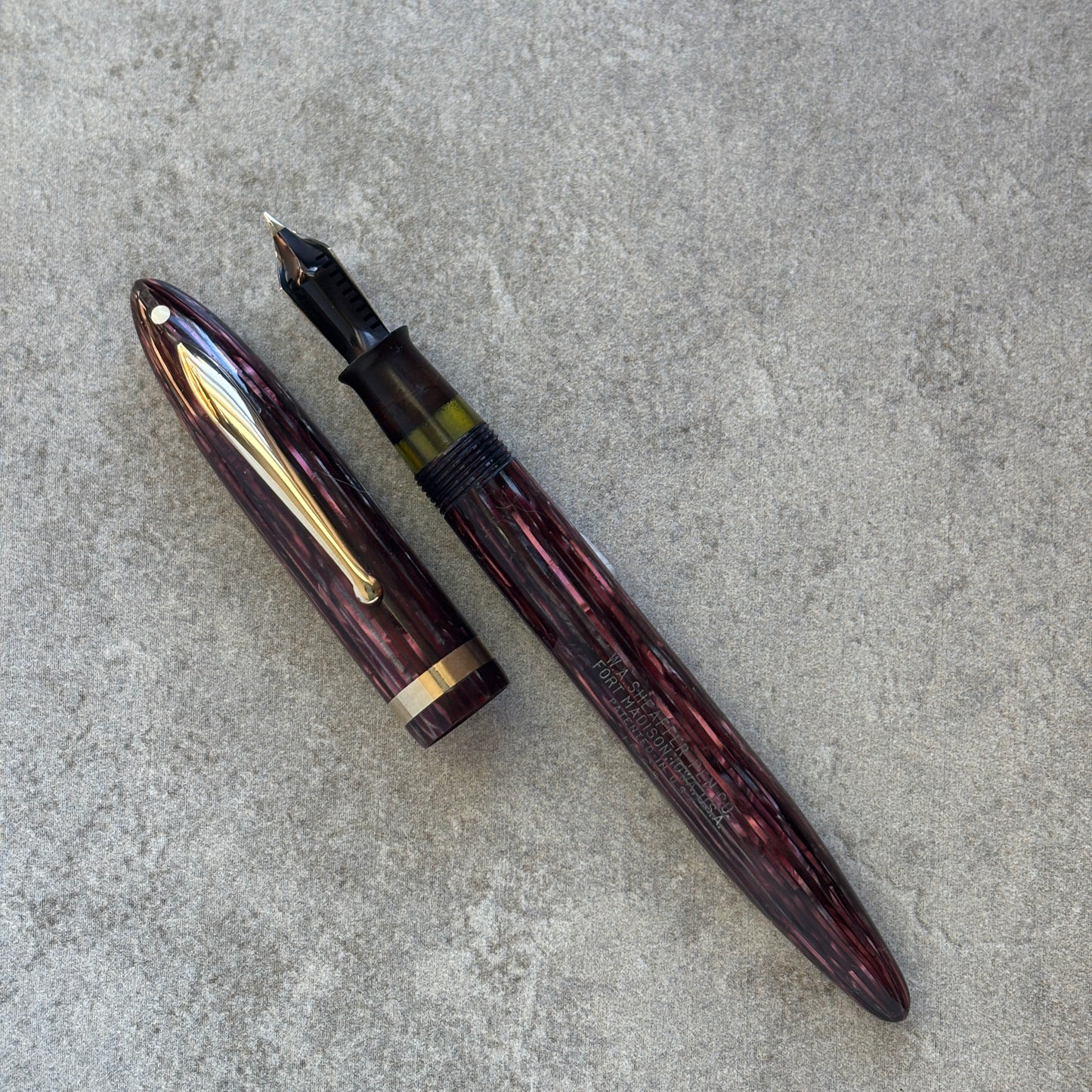 Fountain pen with gold accents on a gray concrete surface
